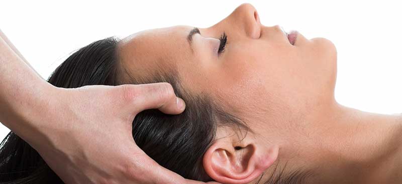 Indiai fejmasszázs háton fekve történik a hajas fejbőrőn keresztül, az arcot is érintve
